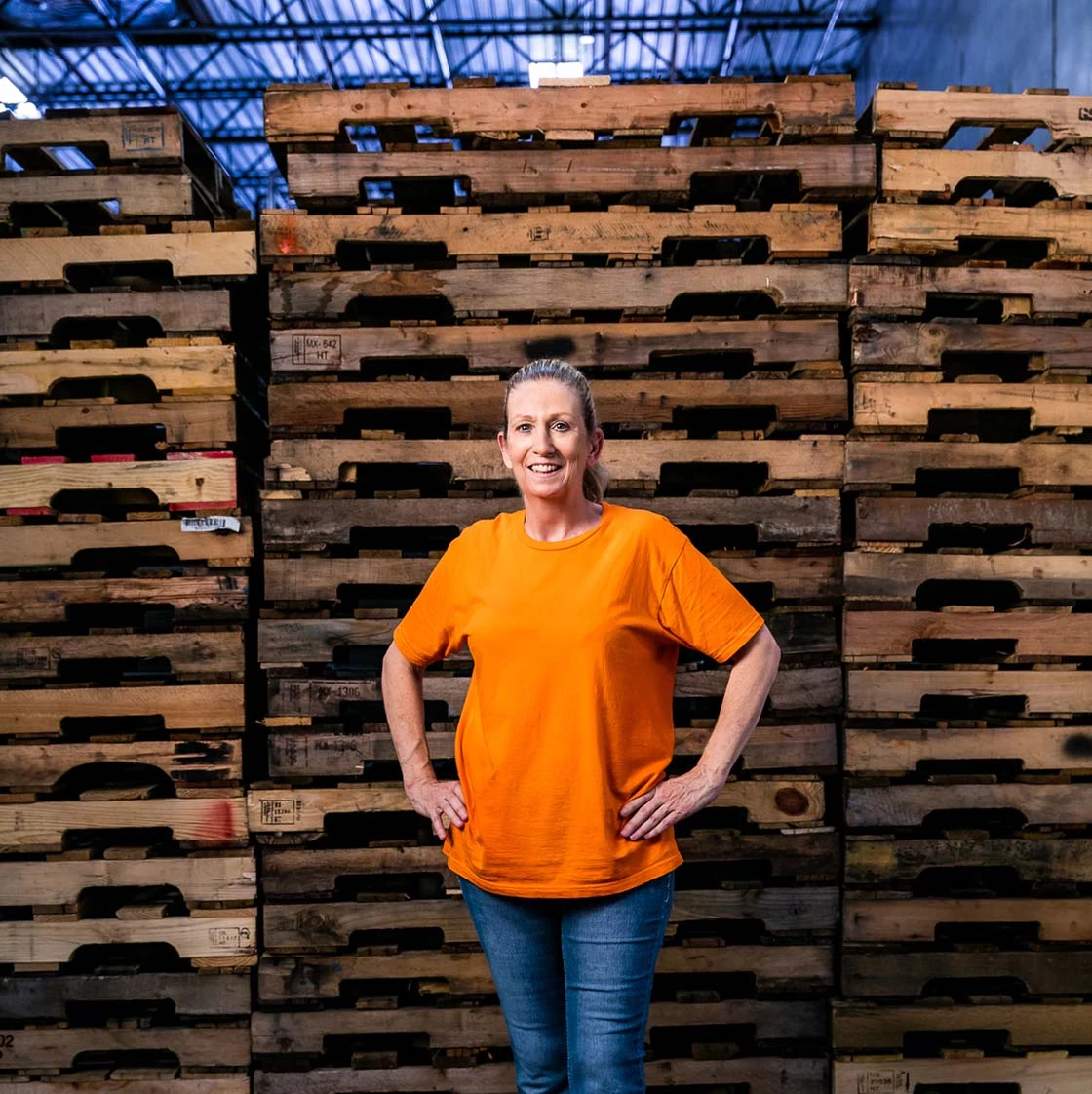 Employee Standing in Front of Wood Pallets